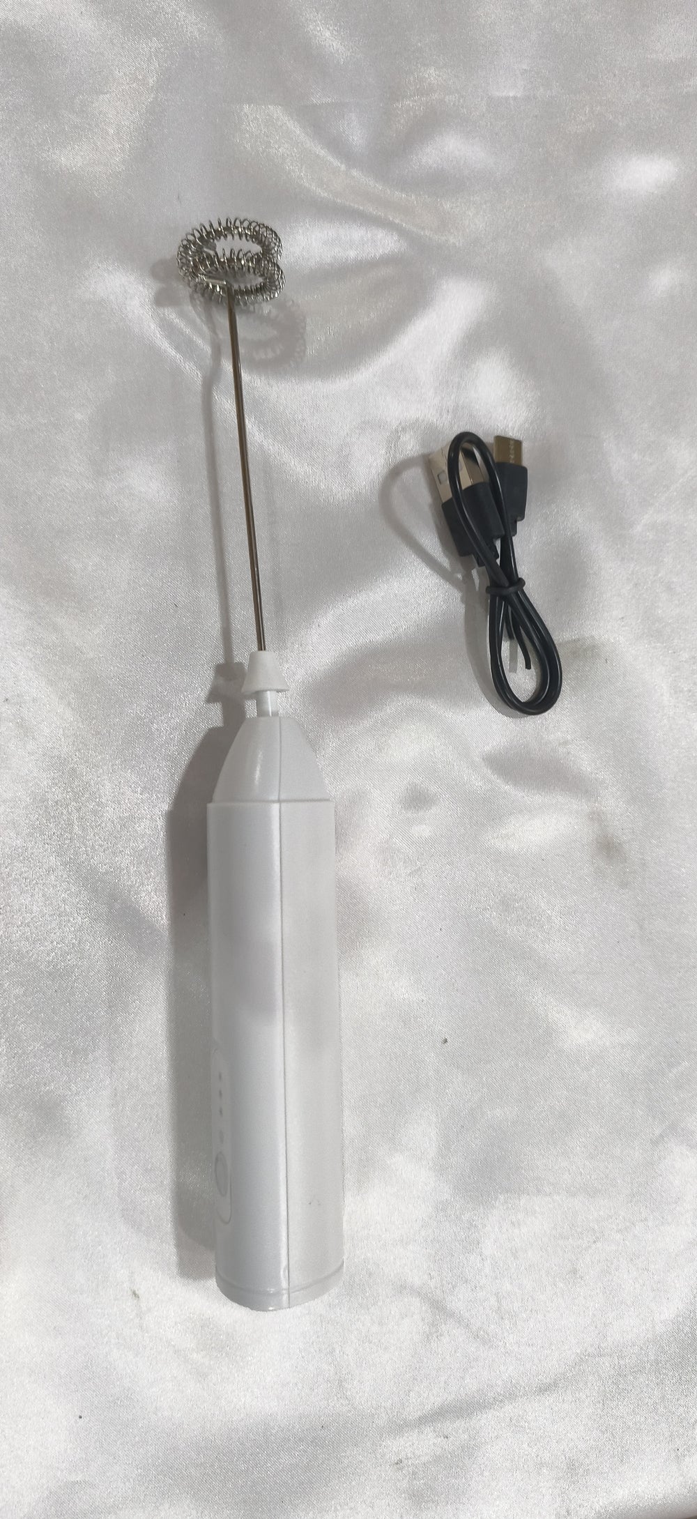 White milk frother with its charging cable