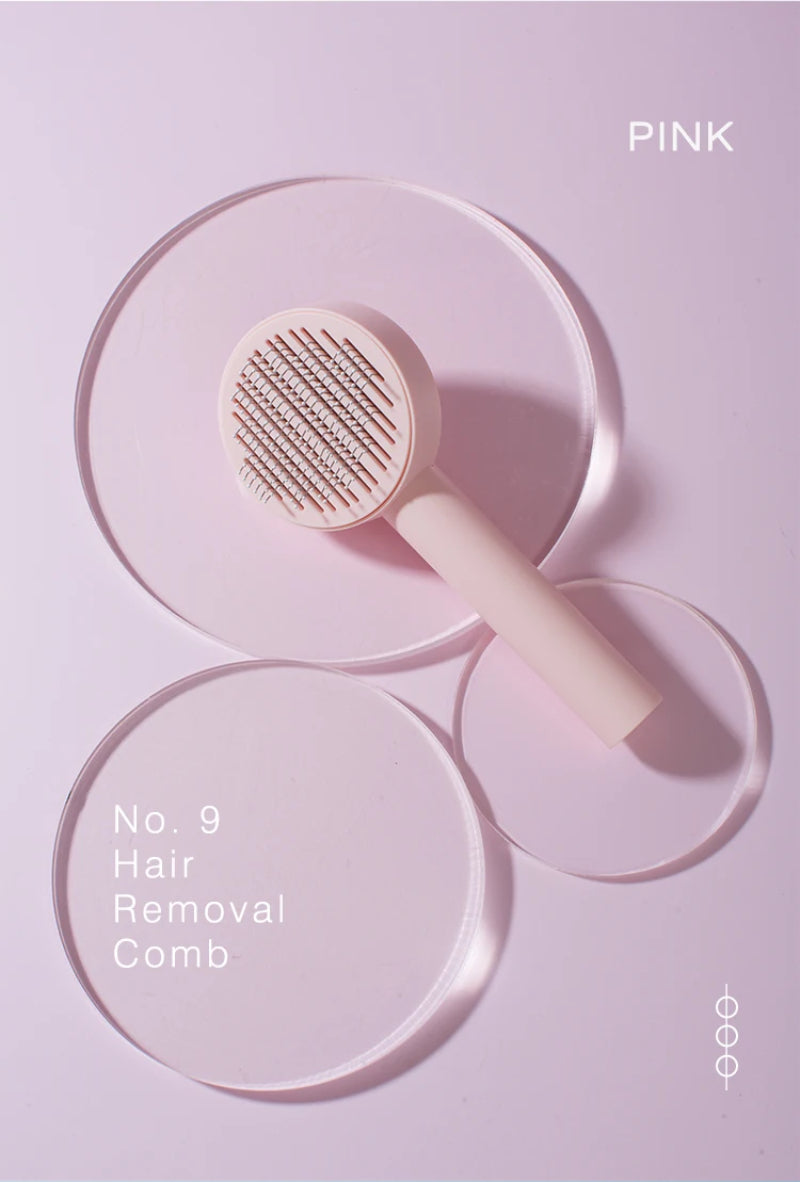 Pink self-cleaning pet grooming comb photographed from above on a pink background.