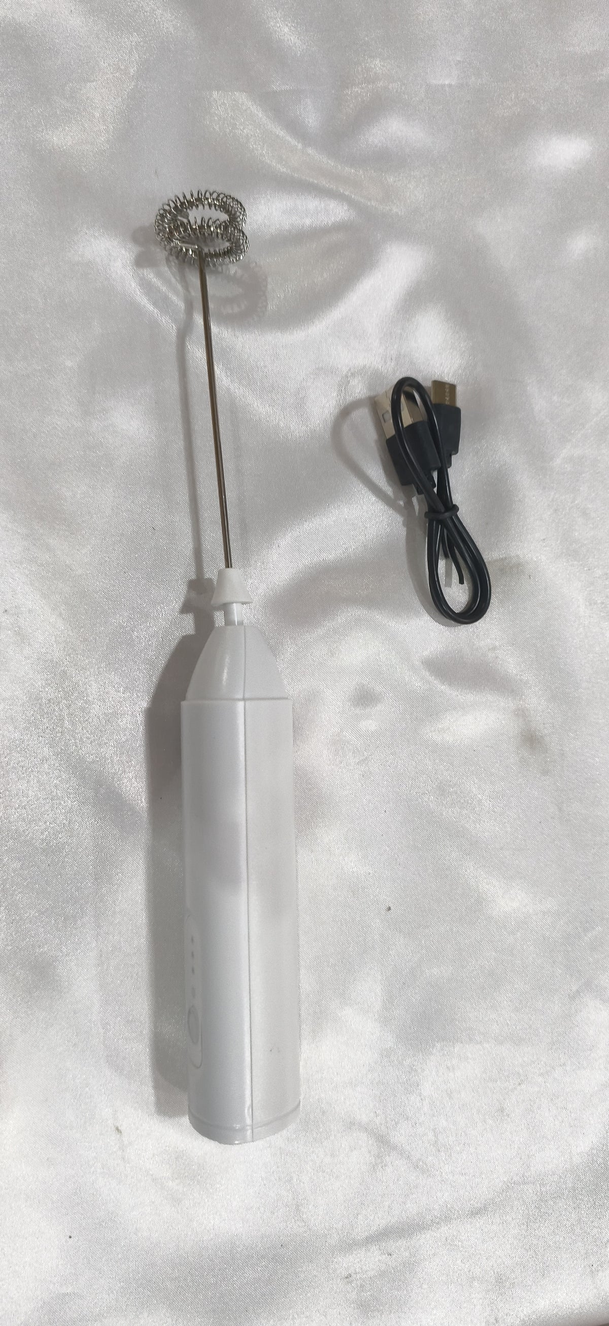 White milk frother with its charging cable