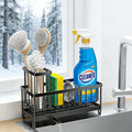 Black sink caddy with brush holder and drain spout, shown with cleaning supplies beside a sink