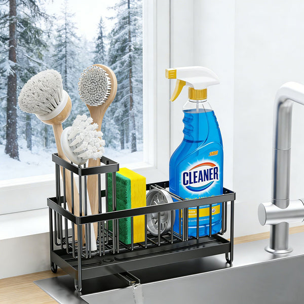 Black sink caddy with brush holder and drain spout, shown with cleaning supplies beside a sink