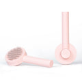 Front and back views of the pink pet grooming comb, showing its pins and round release button.