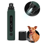 Green nail grinder with its cap and light on, next to a dog