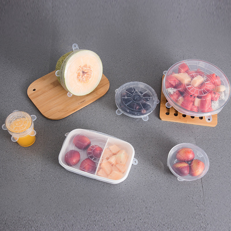 Silicone lids covering bowls and containers of fruit