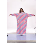 Wearer with arms out, showing the blanket's long sleeves and oversized cut