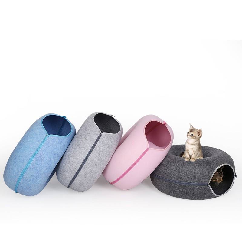 Four tunnel beds in a row with a kitten sitting on the dark grey one