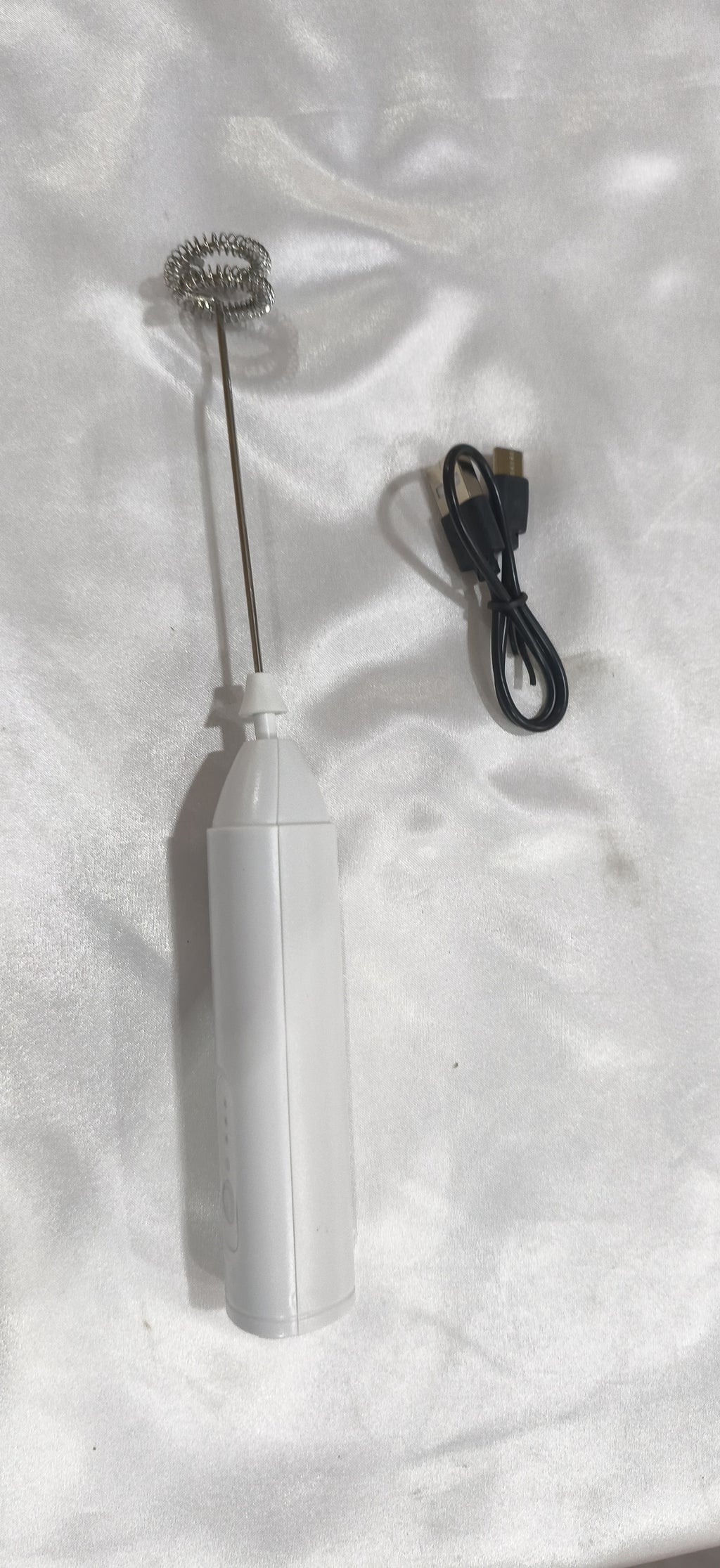White milk frother with its charging cable, from another angle