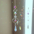 Hanging planet, star and heart decoration with faceted accents reflecting colored light